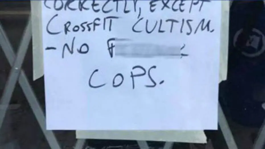 The 'No Cops' sign posted on Atlanta gym door